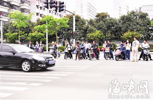 前日，福飞路江厝路口，不少路人闯红灯来到路中央后，准备再度闯红灯过街