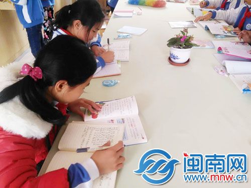 学生一边看书，一边认真做笔记。