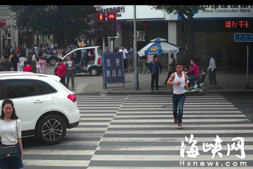 杨桥湖东路口，翟某伊（白衣女）和王某路（背心男），闯红灯被抓拍