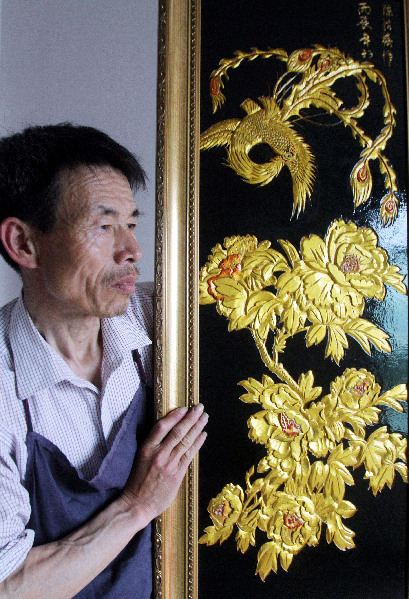 木漆画匠陈绍椿在工作室展示刚完成不久的木雕漆画作品