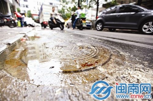 油污从井盖缝隙冒出来