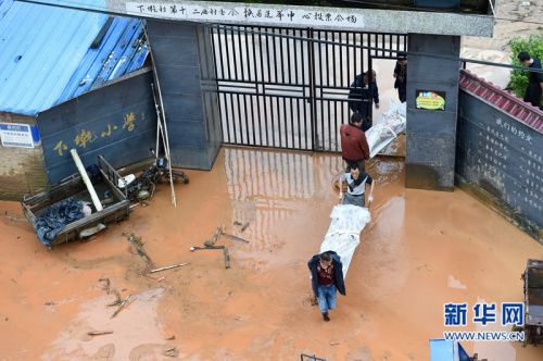 5月9日，在小湖镇下墘村泥石流灾害现场，救援人员抬运遇难者遗体。