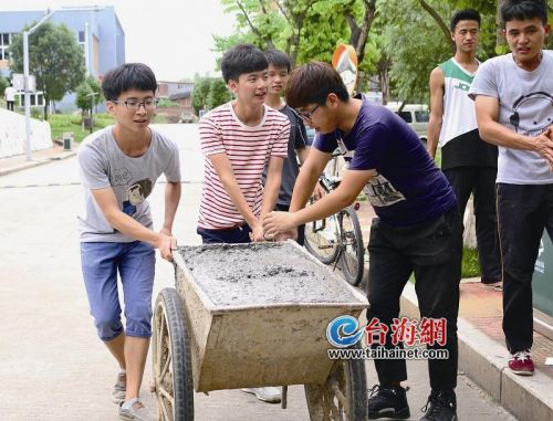 ▲学生借来小车运水泥