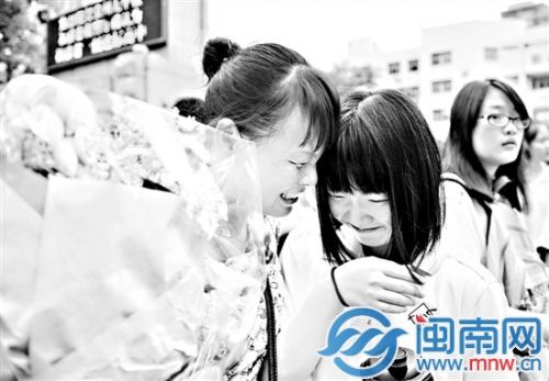 一位母亲捧着鲜花,迎接女儿走出考场