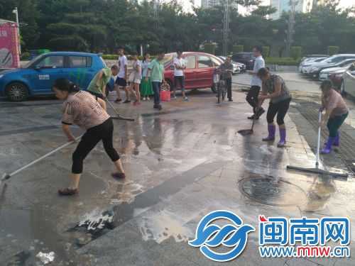 现场清洁工正用烧碱水 清刷油滑的路面