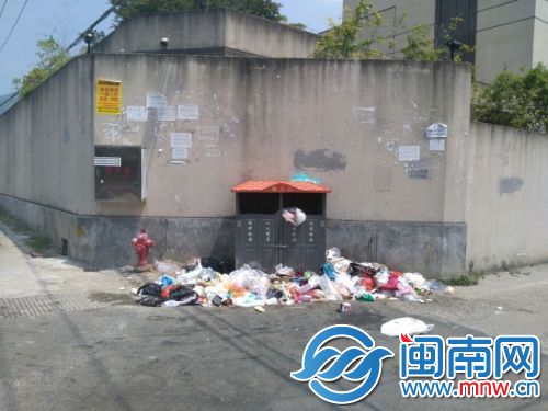 路边一垃圾桶边上堆满垃圾 而垃圾桶没有满
