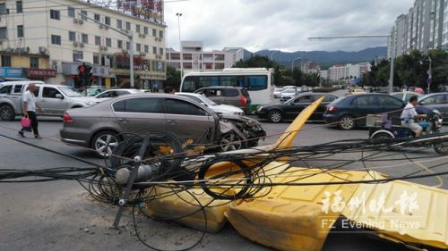 路中电线杆被撞断缆线垂落。