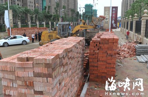 小区附近的横一路两旁堆满了砖头沙子