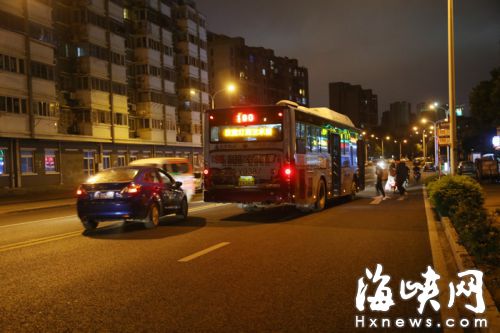 金山卢滨路金山公交总站公交站路段，公交车停在仅有两个车道的路中间上下客，后面的小车压黄线绕过