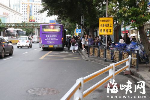 双抛桥站,不少乘客在车道上候车,公交只能停进半个车身