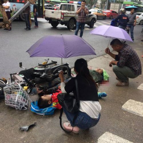 不少市民主动上前为母女二人撑伞