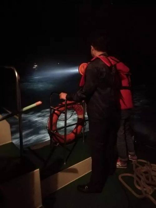 海事人员携带探照灯在事发海域附近搜寻