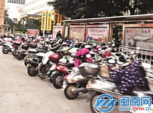 高峰期，宝洲街万达段机动车道一侧违停电动车包围公交站台