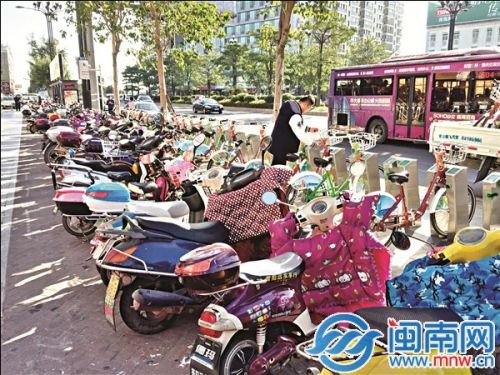 公共自行车被电动车围堵，市民借车只能从旁边缝隙挤出来