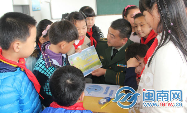 图为官兵向学生讲解节水常识.jpg