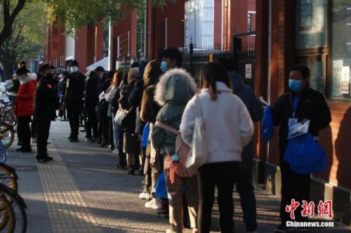 资料图:2020年11月29日,中央机关及其直属机构2021年度考试录用公务员笔试正式开考。图为北京市东城区一考点外,工作人员在核验考生信息。<a target='_blank' href='http://www.chinanews.com/'>中新社</a>记者 蒋启明 摄 点击进入下一页