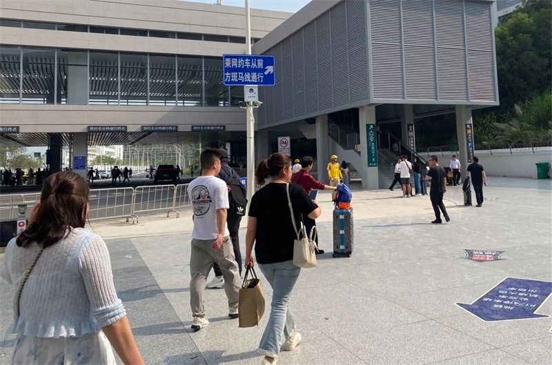 旅客沿着标识前往网约车上客区。  