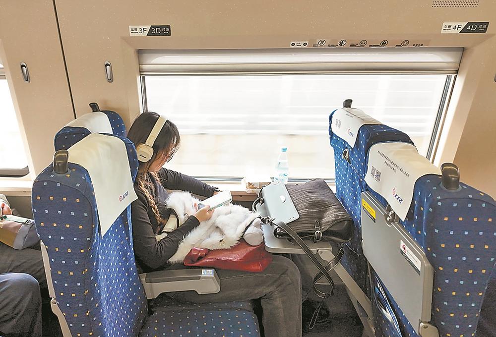 旅客在静音车厢佩戴耳机看手机。