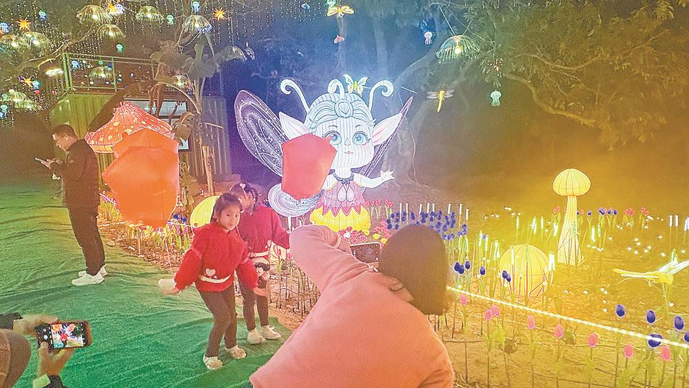 市民游客在荔林花灯下游玩拍照。 陈阳阳 摄  