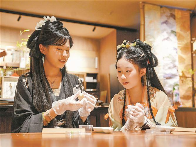 &ldquo;嶼見閩南&rdquo;主題景區(qū)內(nèi)，游客身著古風(fēng)服飾，體驗制作茶菓子?！　。ㄓ浾?盧劍豪 攝）