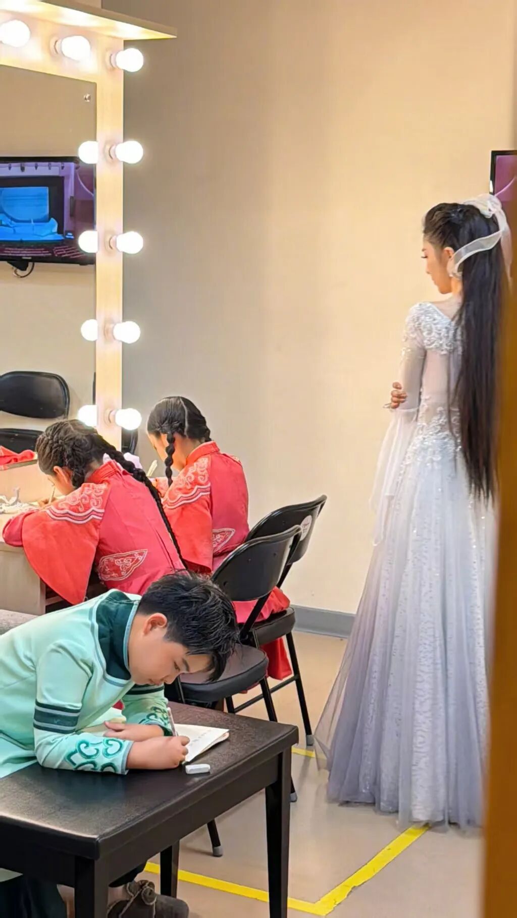 佟麗婭穿著仙女裙 在演出后臺給孩子報聽寫