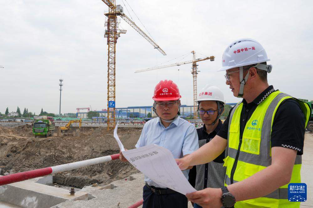 5月7日，仪征市数据局的工作人员（左）在辖区内一处施工现场协调解决建设项目施工中存在的问题。新华社记者 李博 摄