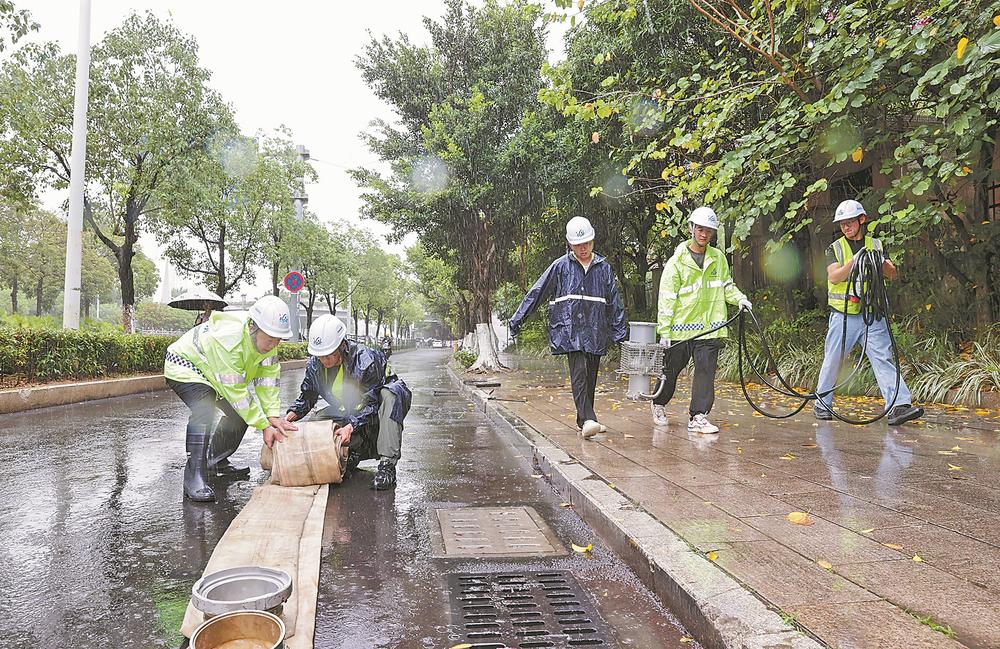 高考期间,相关部门切实做好护考应急防范准备。图为8日,泉州市政排水公司工作人员在城东中学考点外布置排水设备。张九强 摄