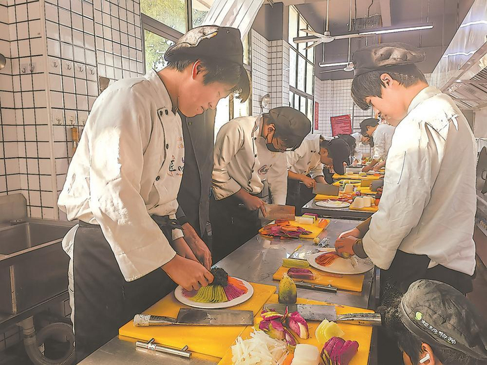     福技中安餐饮产业学院的学生正在给果切摆盘。  赵文娟 摄