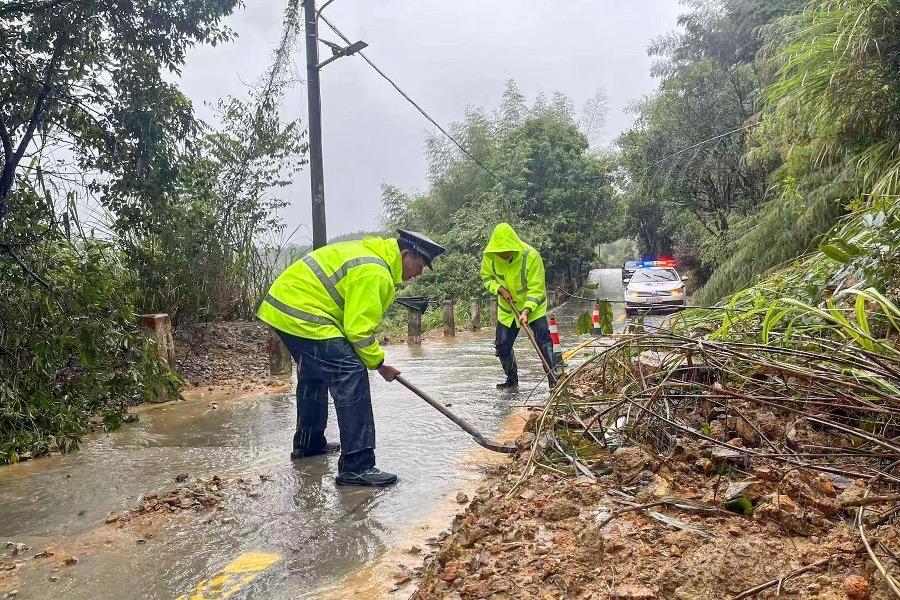 在德化雷峰镇351县道滑坡区域，雷峰派出所民警布设反光锥形筒，引导过往车辆减速绕行，清理路面泥沙和滚落碎石，快速恢复道路通畅。