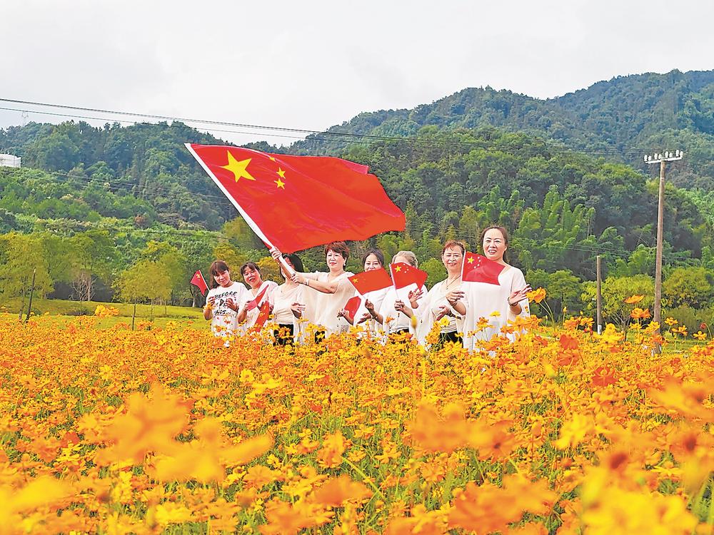 1日，在三明生态新城湿地公园，游客在盛开的花丛中合影。俞和江 摄