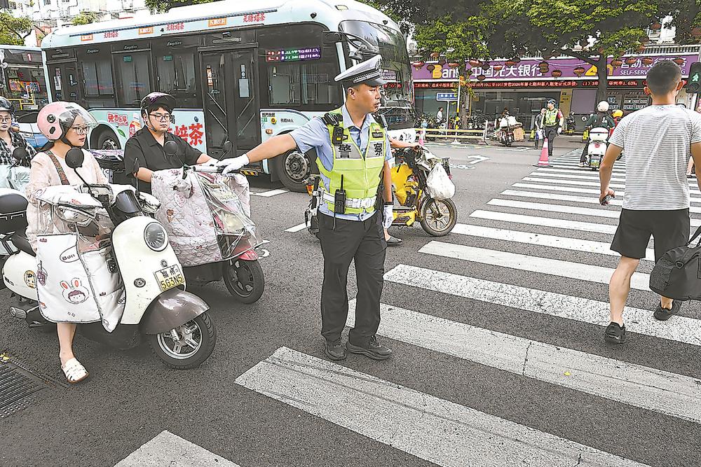 5日，福州市三坊七巷景区客流持续处于高位，杨桥路、南后街沿线通行压力陡增。福州交警在沿线核心路口、景区出入口增派值守警力，引导人车有序分流，保障景区周边道路通行安全有序。本报记者 游庆辉 摄